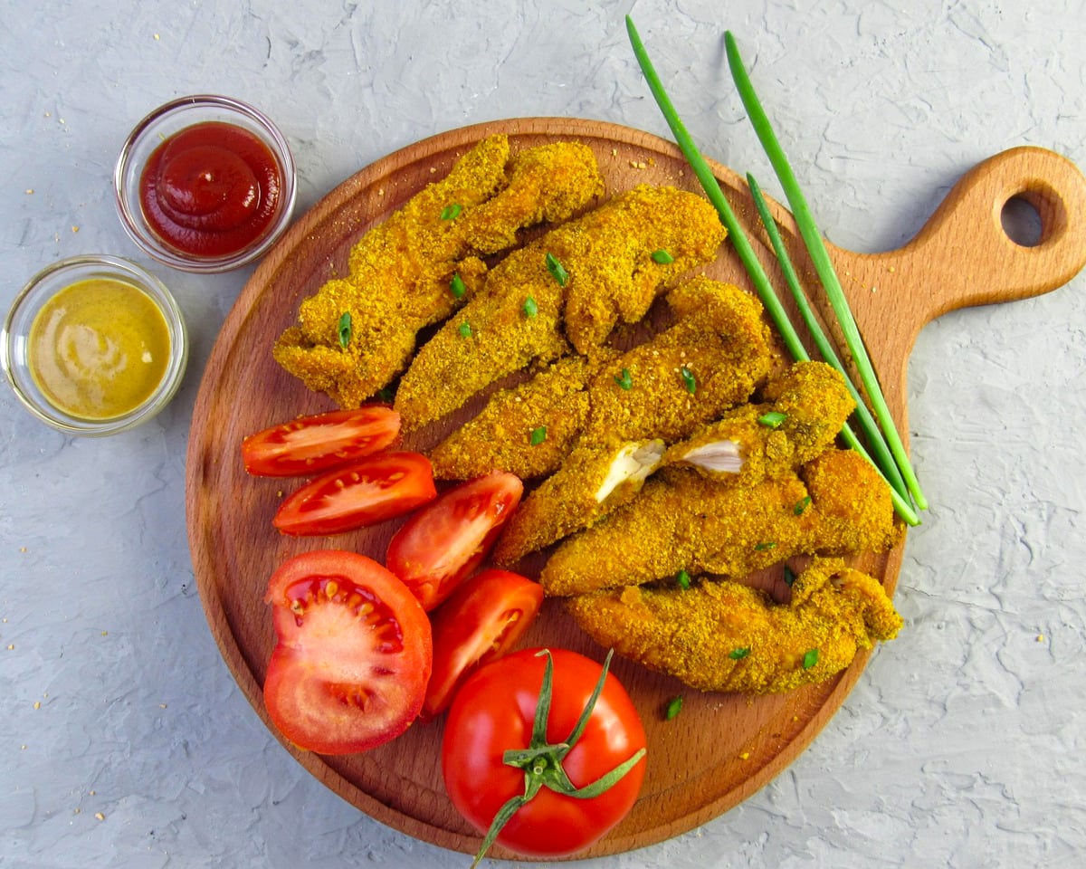 Crumbed chicken strips with ketchup and mustard dips